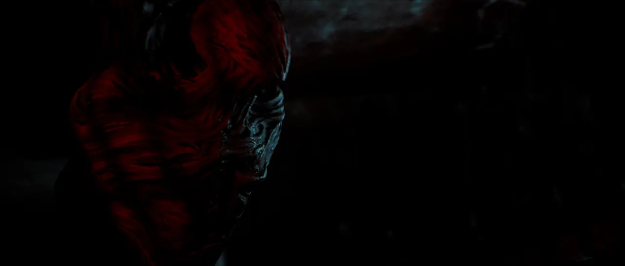 A dark frame with a creature's face lit red.